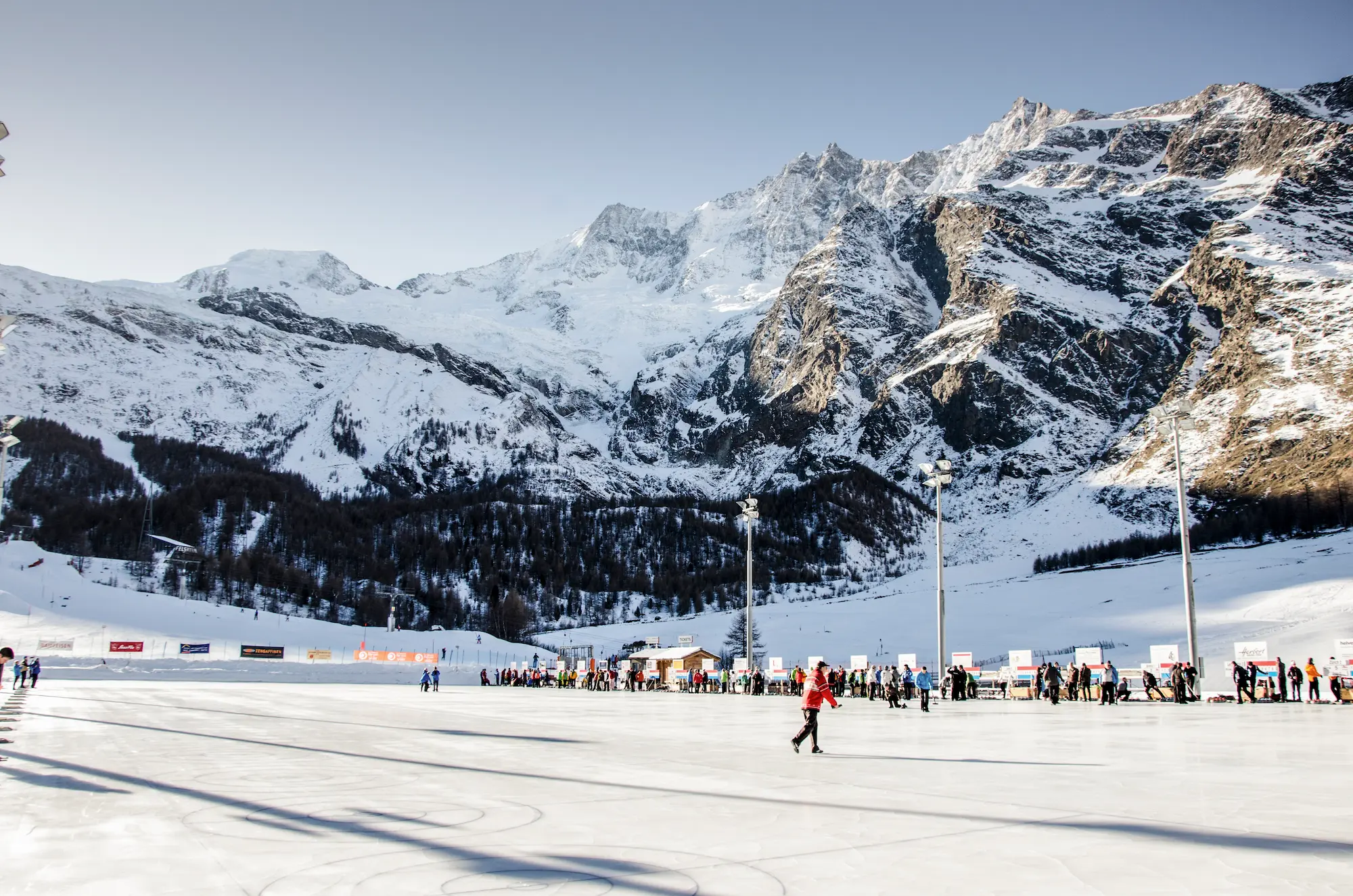 Two elegant cocktail glasses with olives beside a tennis ball on a sunlit table, evoking a luxurious summer tennis lifestyle.