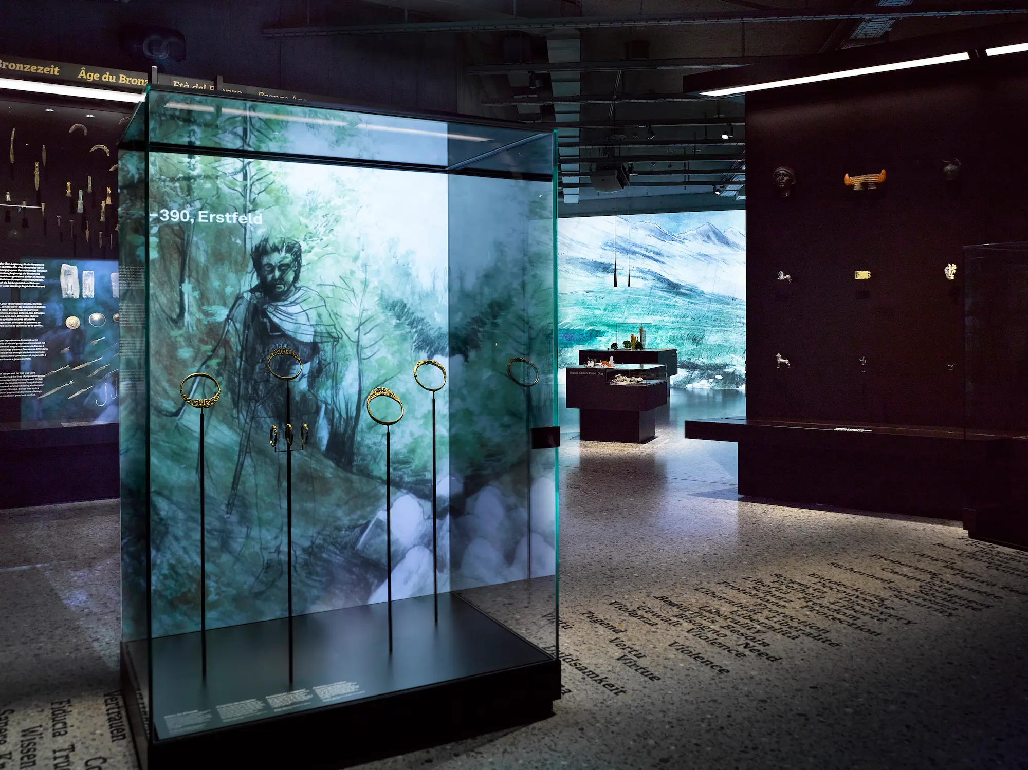 Immersive archaeology exhibition at the Swiss National Museum featuring Bronze Age artifacts including gold jewelry and torcs displayed in illuminated glass cases with multimedia projections showing prehistoric Switzerland, offering affluent visitors world