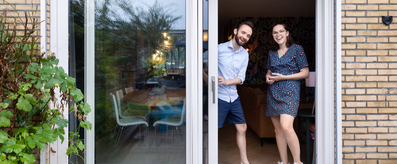 Man en vrouw staan in deuropening van een woning.