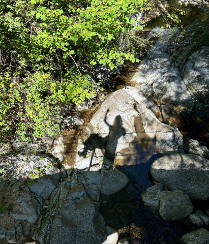 Umbra pe stâncă în mijlocul naturii, simbol al călătoriei interioar