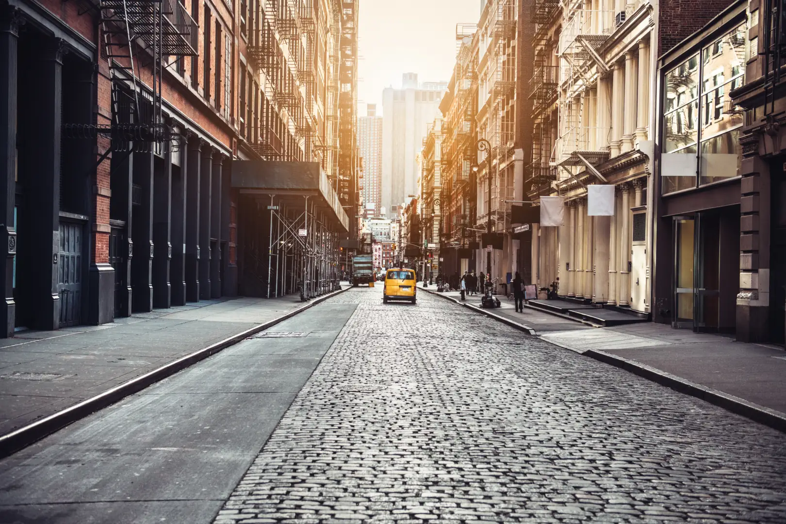 Cobblestone street lined with cast-iron buildings in SoHo, Manhattan, at sunset