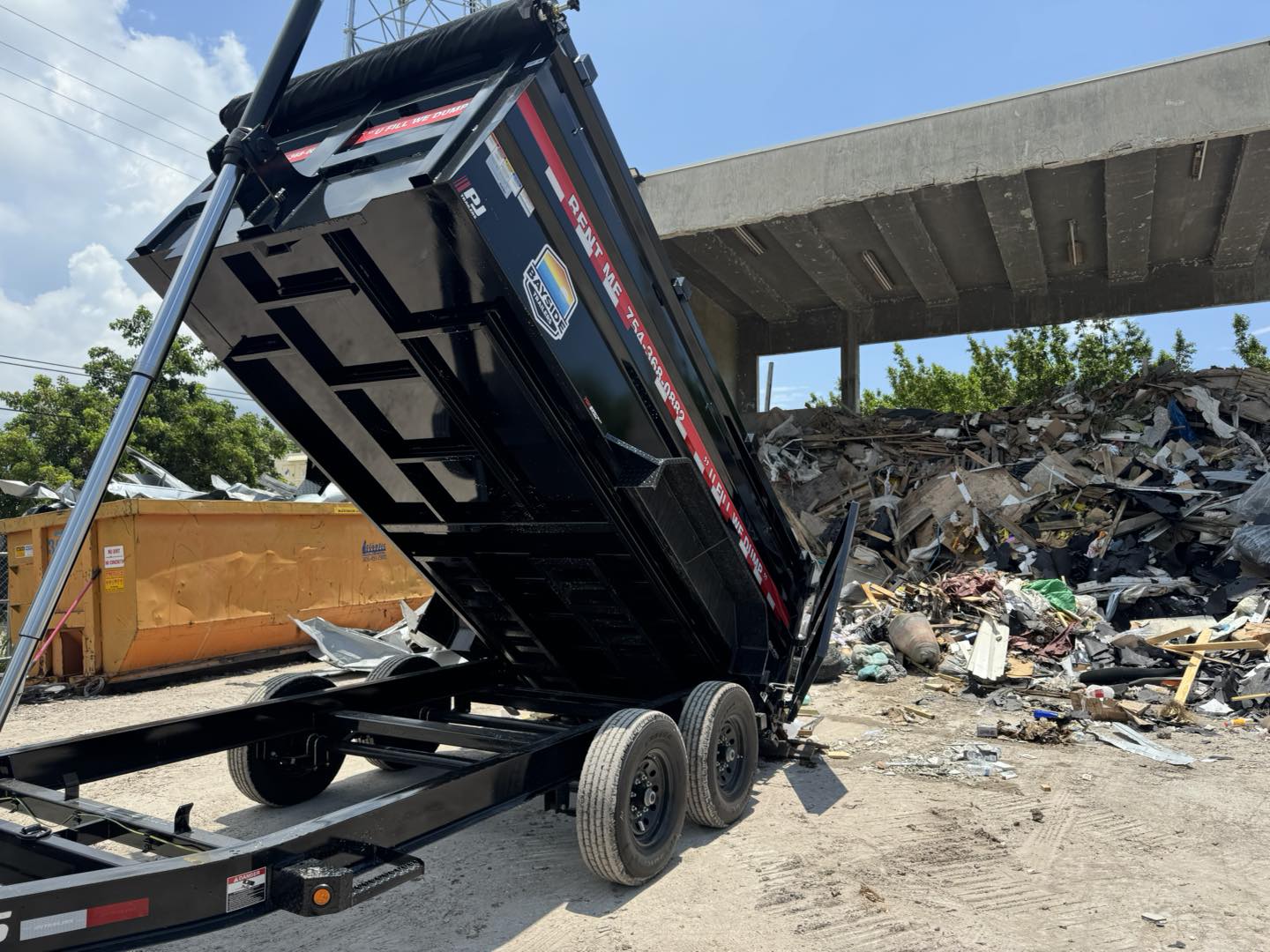 Bayside Trailers dumpster rental full of debris being dumped.