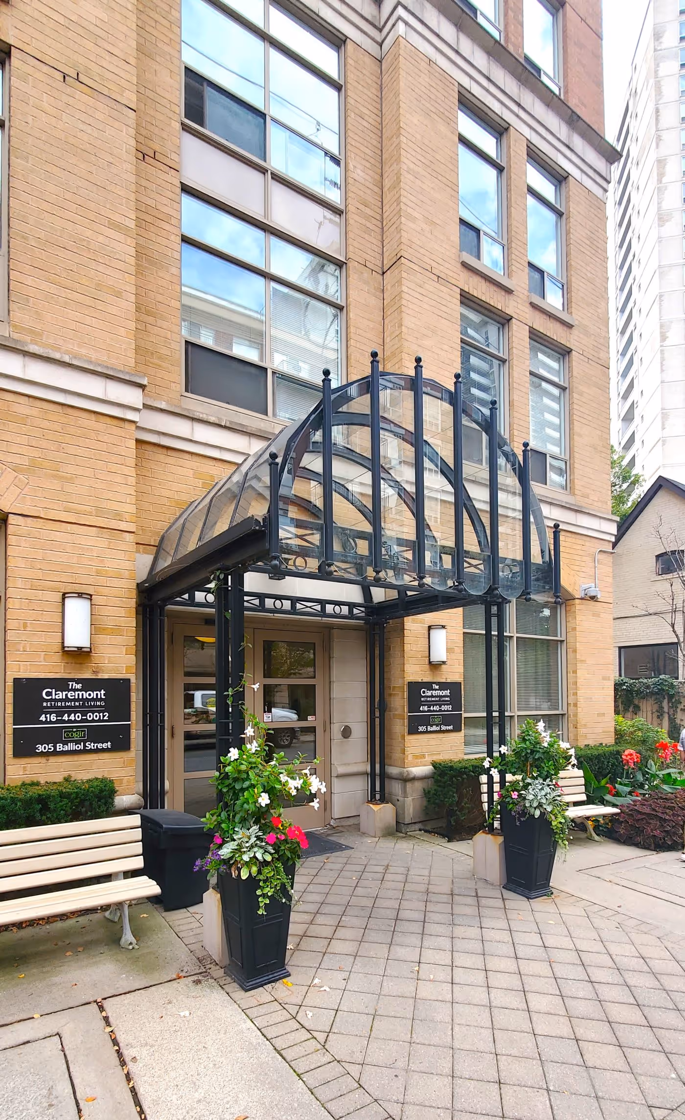 Annuals planted in urns and commercial building entrance