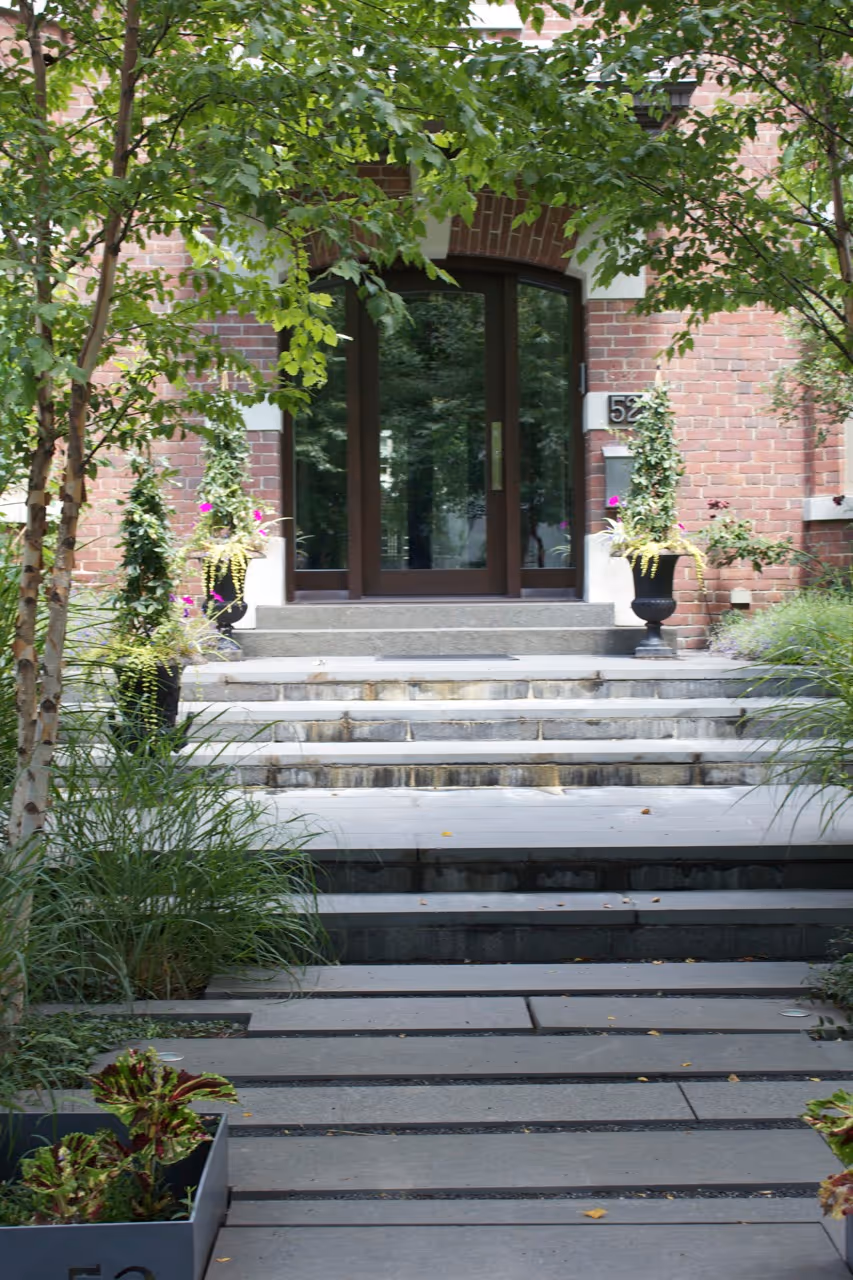 Stone walkway leading up to the front the property with garden beds on either side