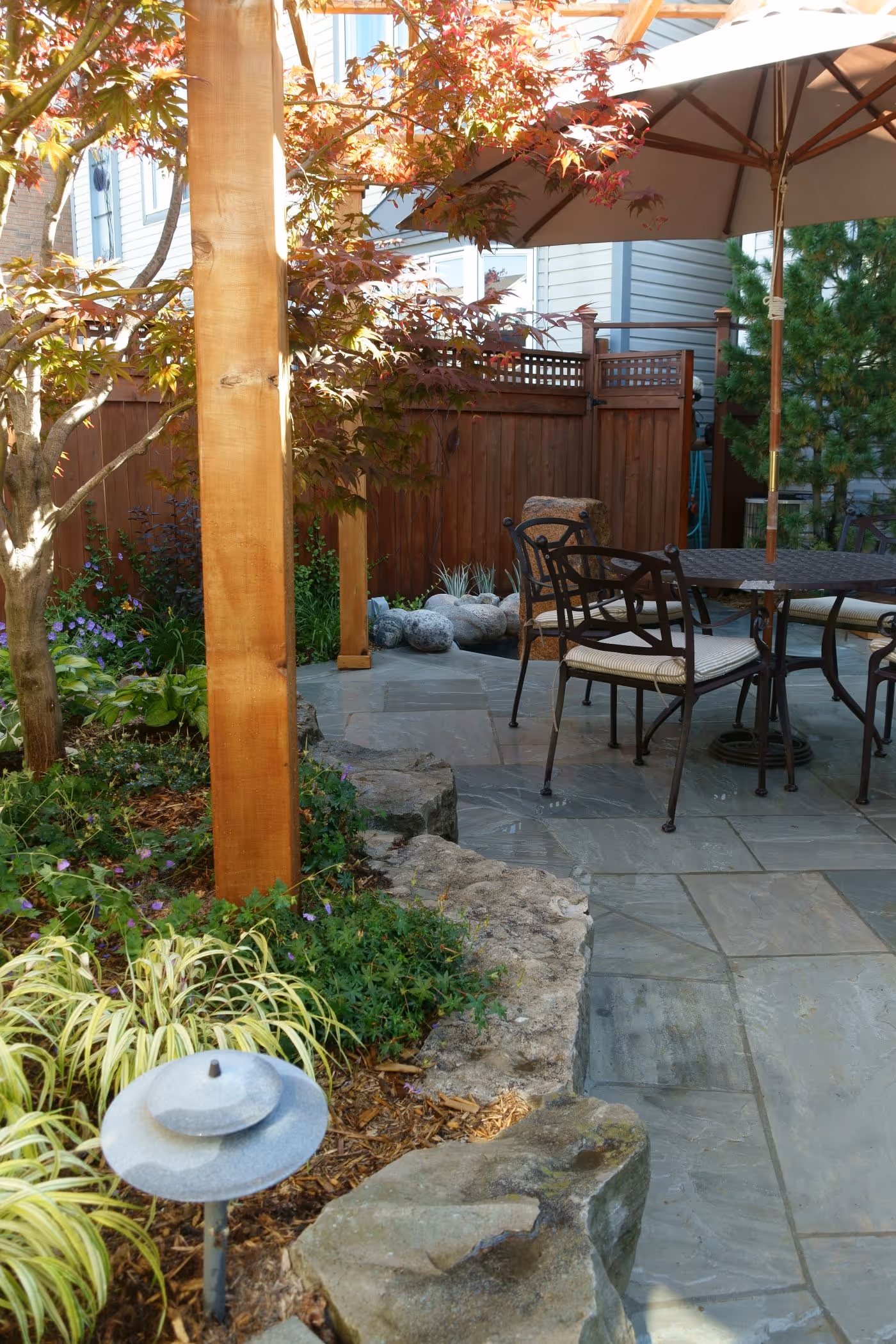 Pergola and stonework next to stone retaining wall garden bed
