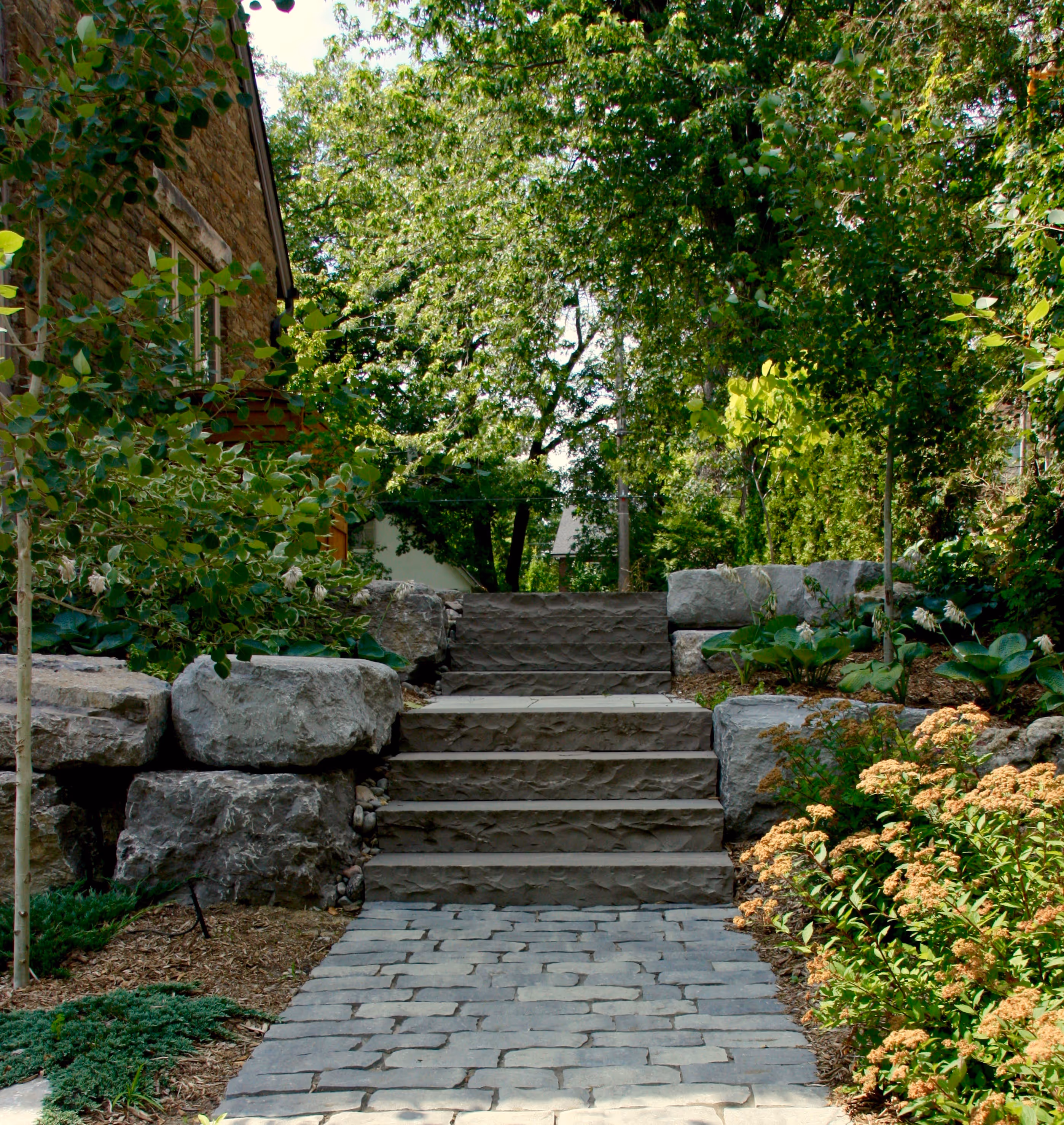 stone steps leading up from backyard to front of the house. Custom Built