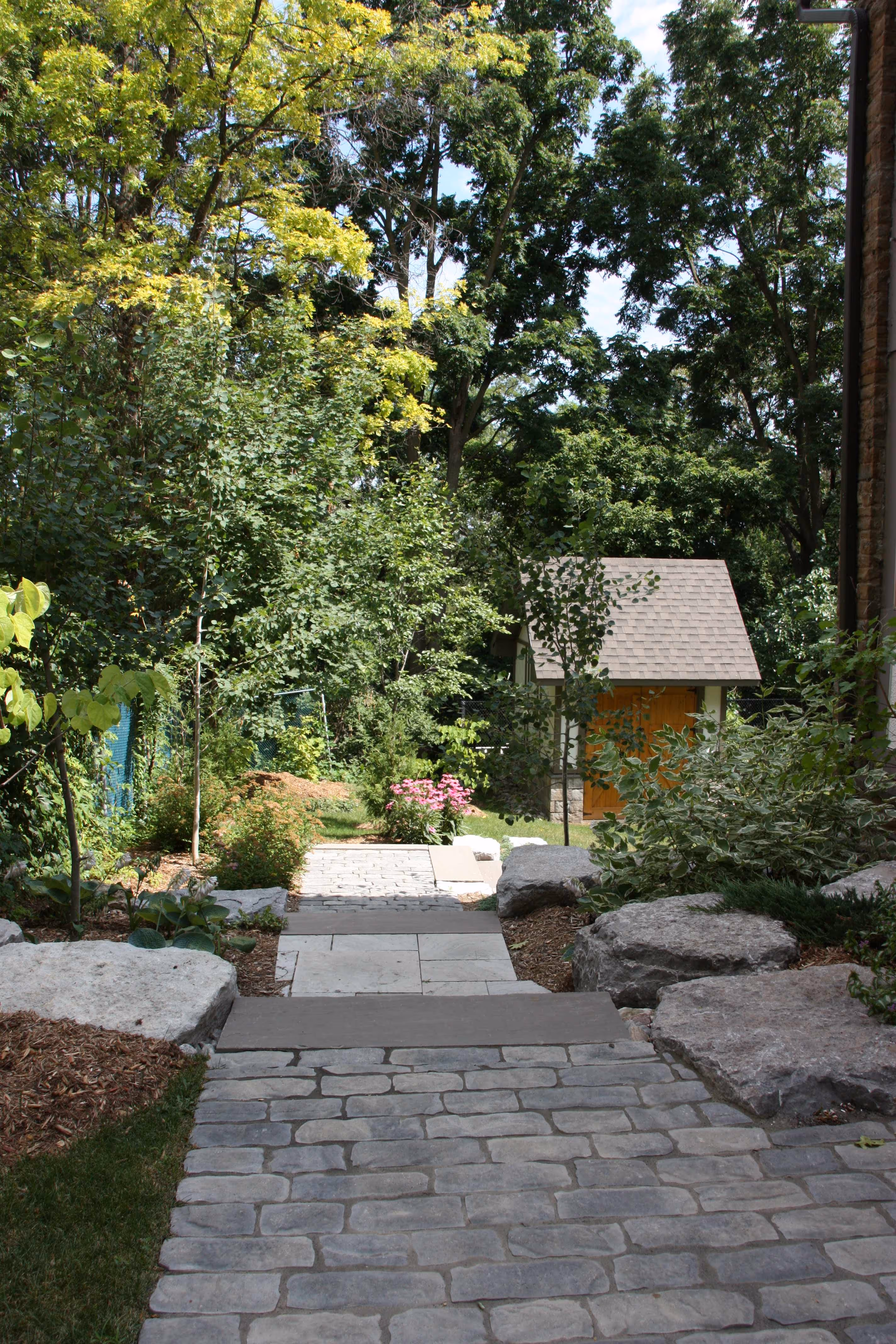 custom built interlock stone steps leading to backyard lawn