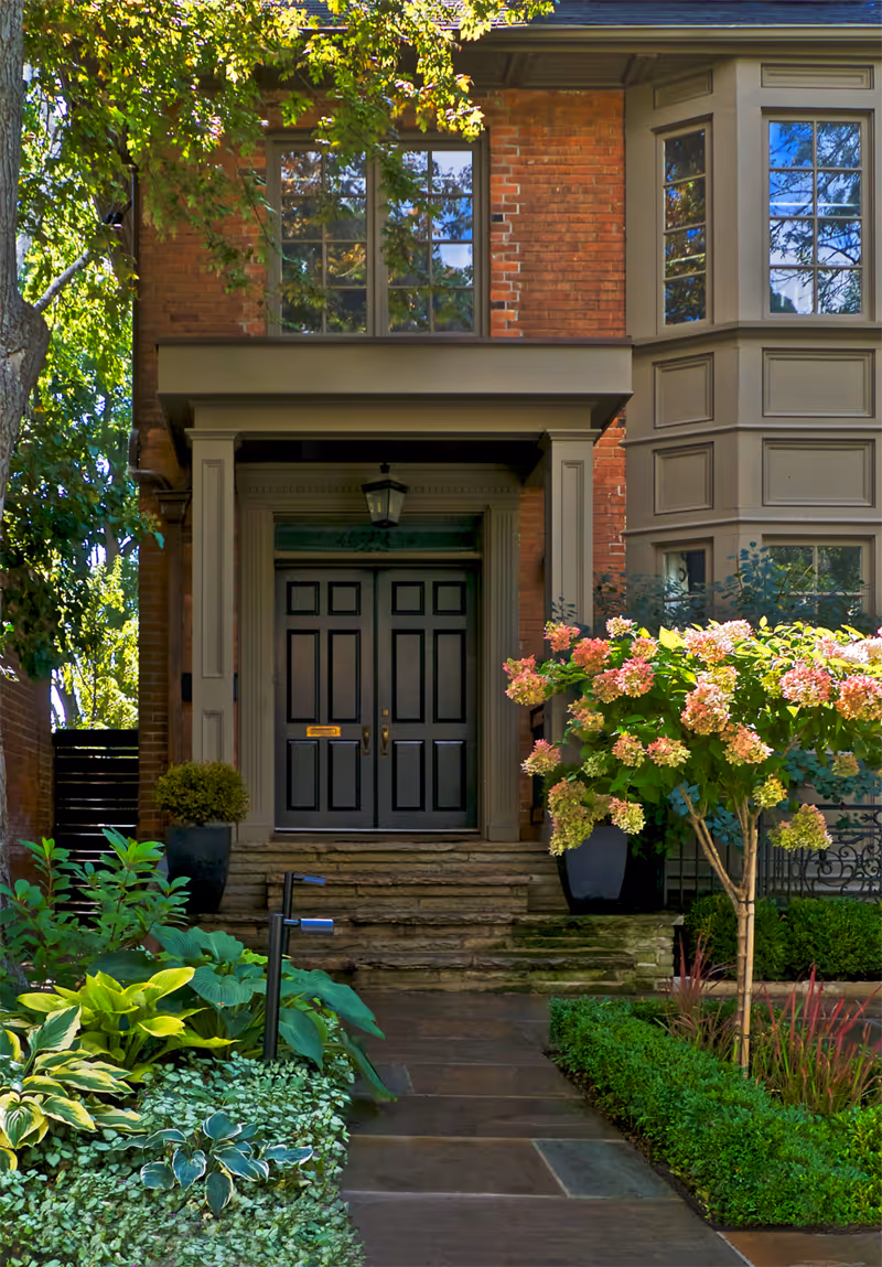 Front entryway through the boxwoods. Beautiful short trees mark the path up