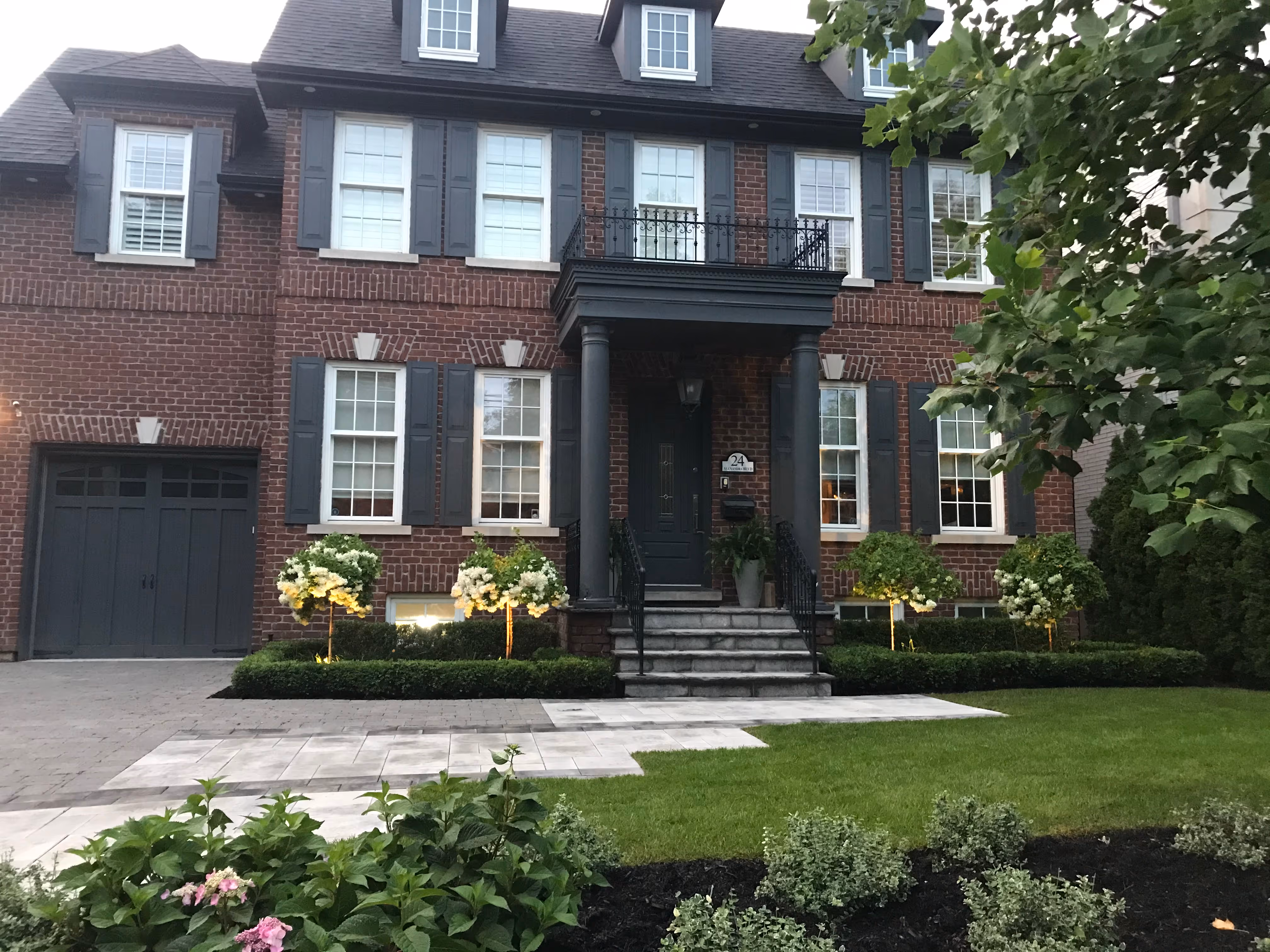 Front of the property with grass and beds filled with Perennials and black stained mulch