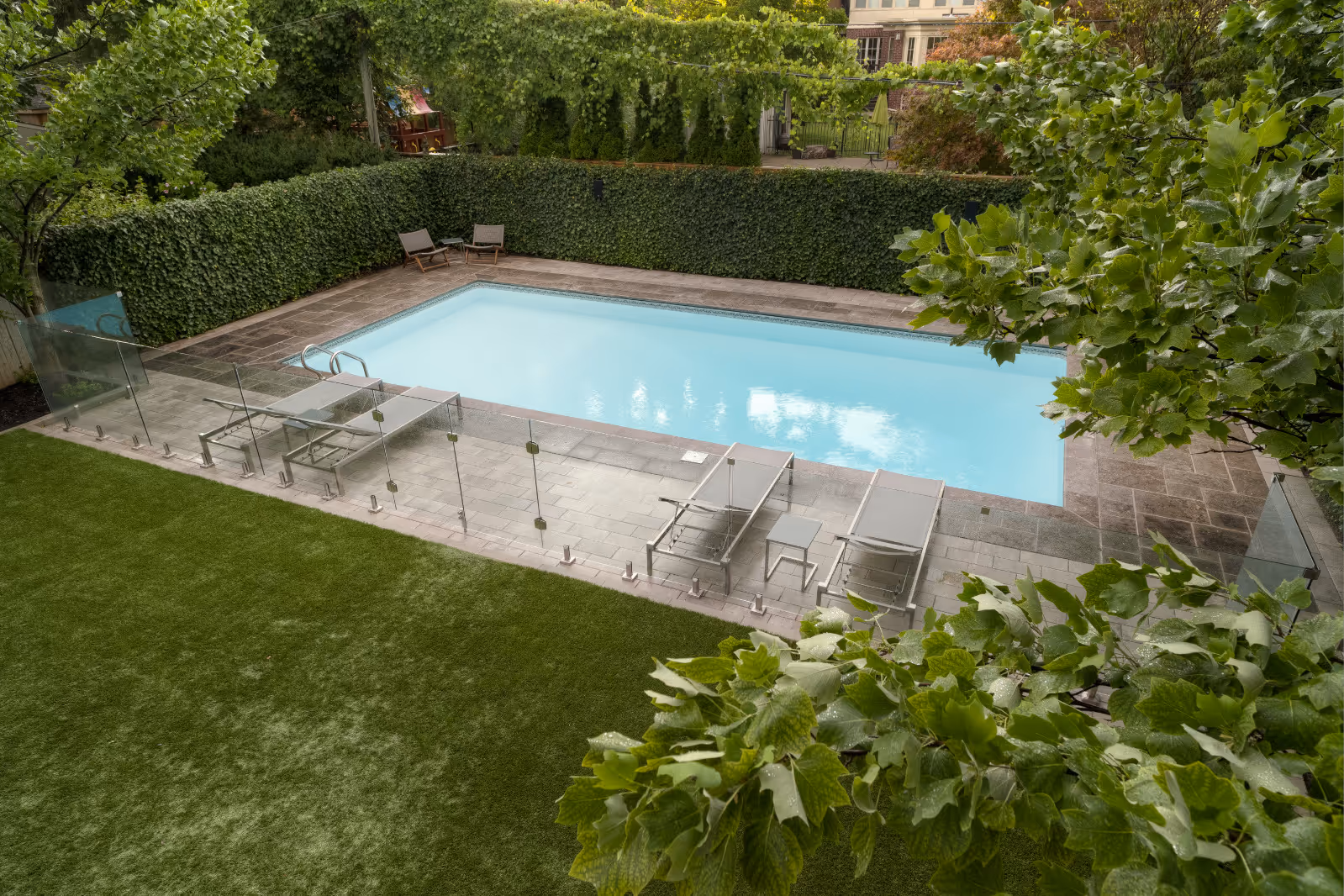 Artifical turf with stone and glass enclosed pool