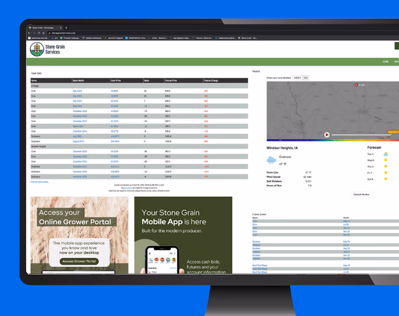 Computer monitor displaying Stone Grain Services website with cash bids table, weather forecast, and mobile app promotion.