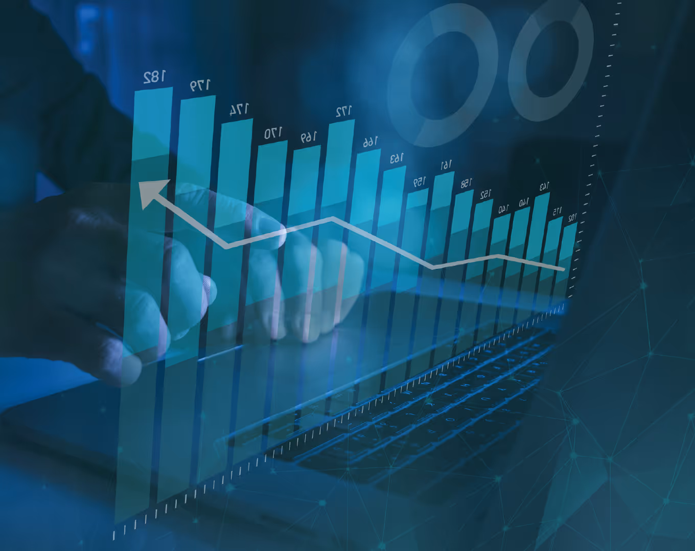 Transparent bar chart with numerical data and a descending arrow overlaid on hands typing on a laptop keyboard.