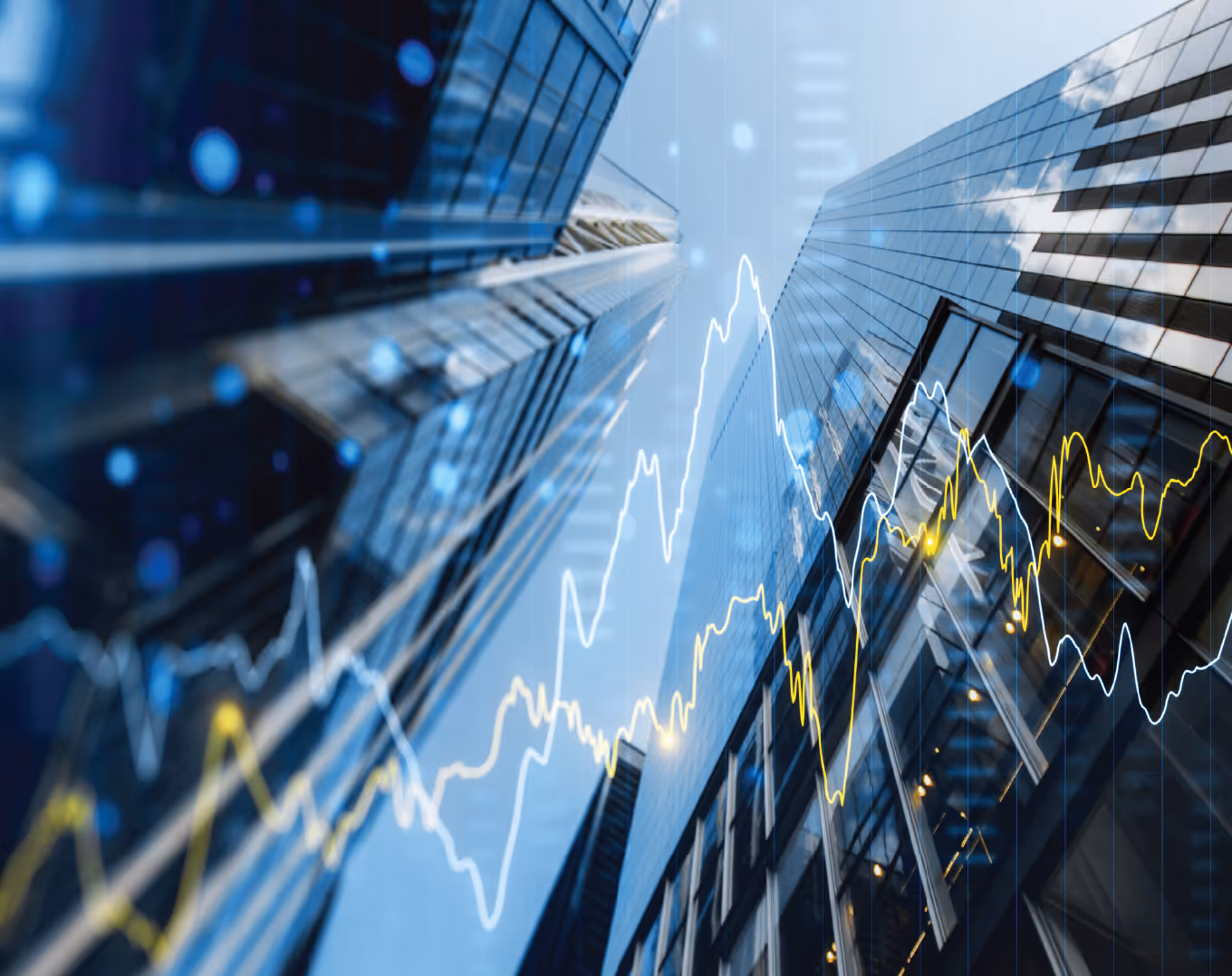 Upward view of modern glass skyscrapers with overlaid white and yellow financial stock charts.