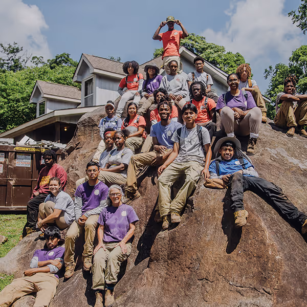 Howard Student Interns pose on a boulder