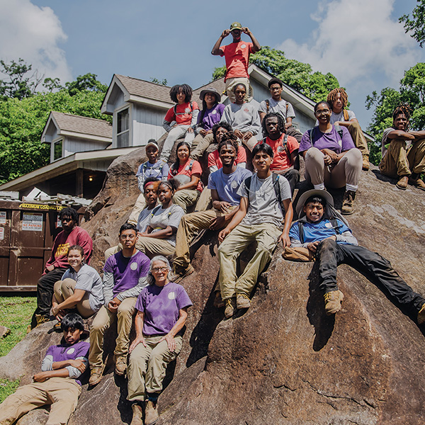 Howard Student Interns pose on a boulder