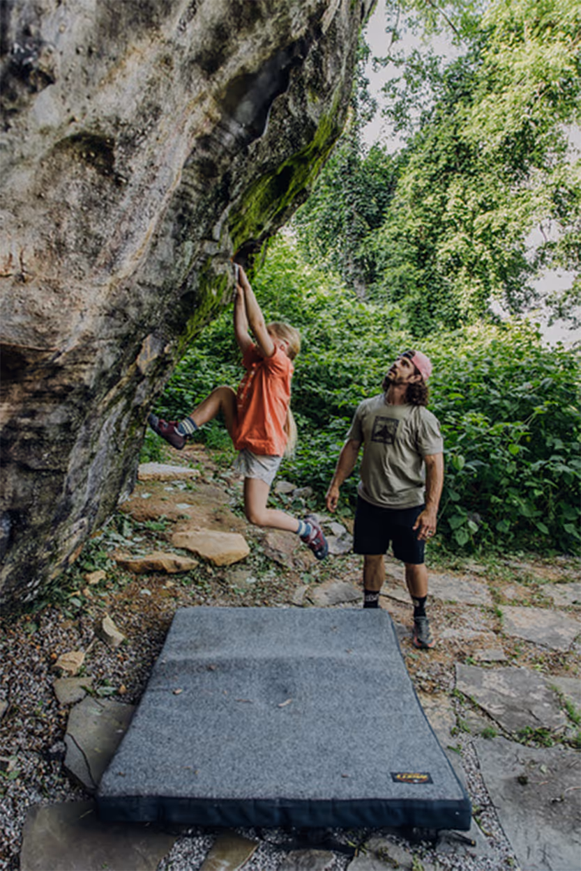 A family climbs the boulders in the bouldering field at Lookout Mountain Conservancy