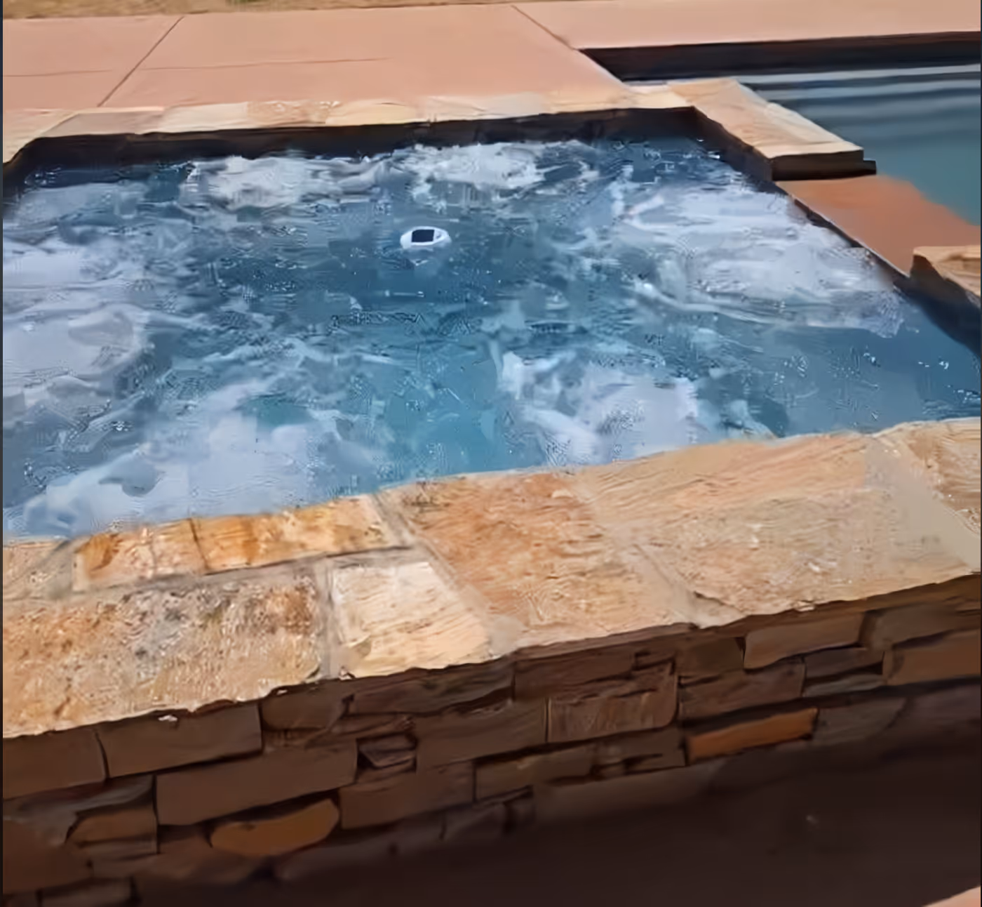 Custom hot tub made of natural stone in Amarillo Texas by Lone Star Luxury Pools
