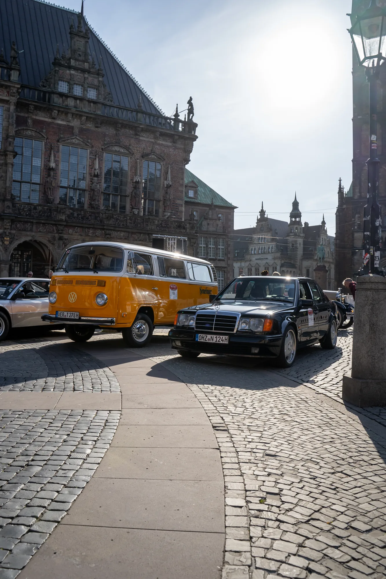 Oldtimer und gelber VW-Bus vor dem Bremer Rathaus bei den BOC 2024.