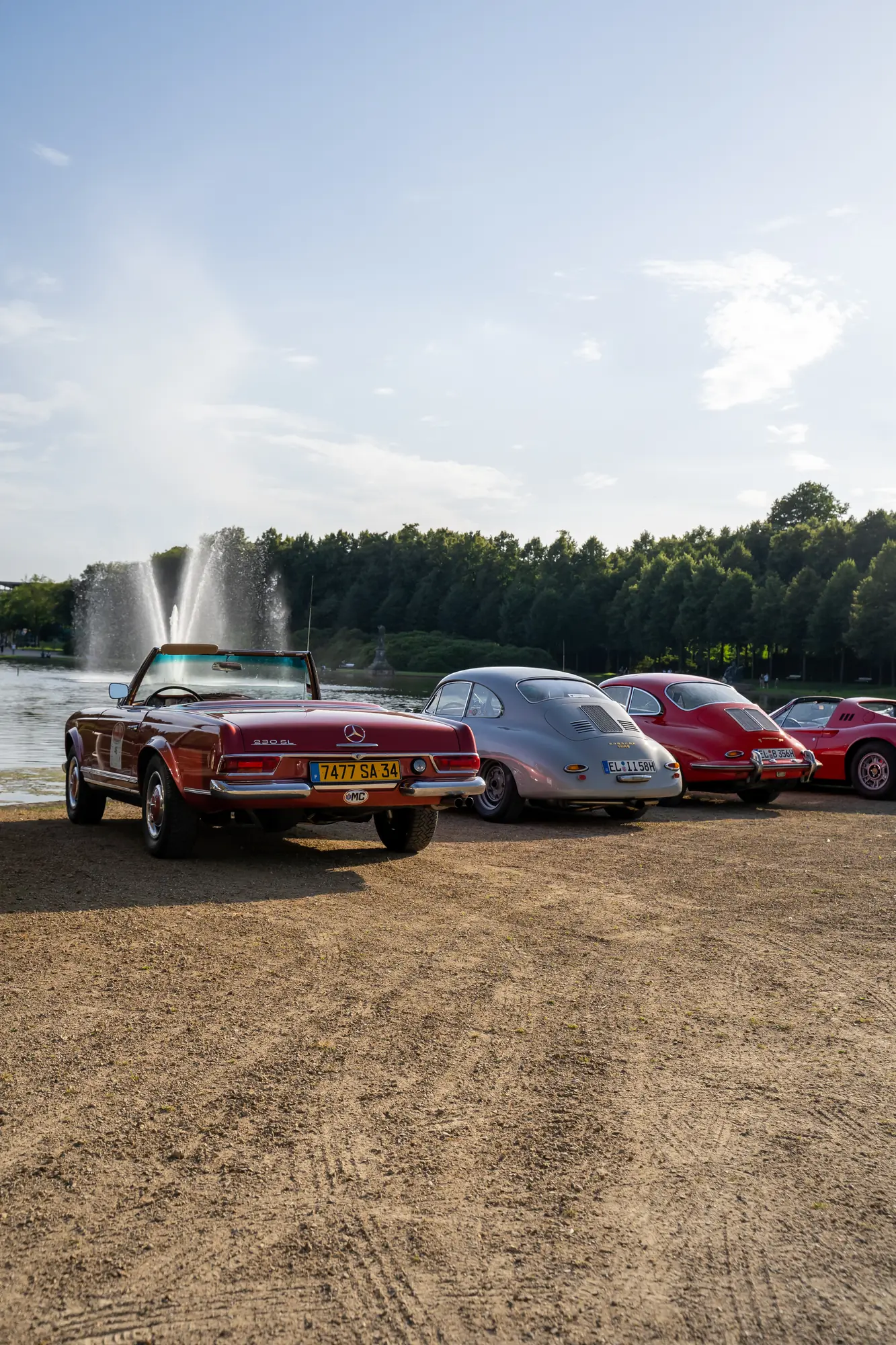Oldtimer am Wasser mit einer Fontäne im Hintergrund bei den BOC 2024.