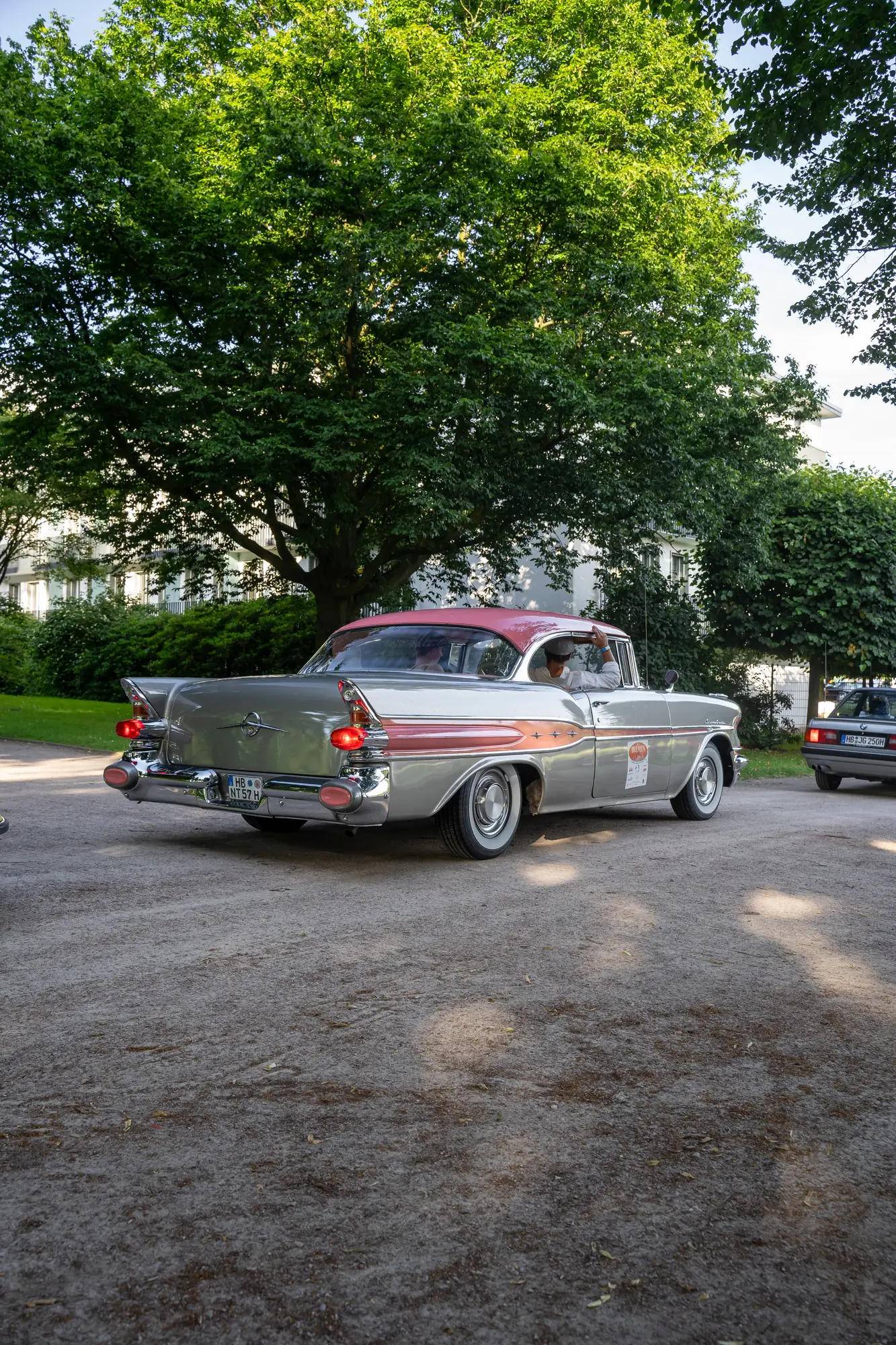 Silbernes Coupé unter Bäumen bei den BOC 2024.