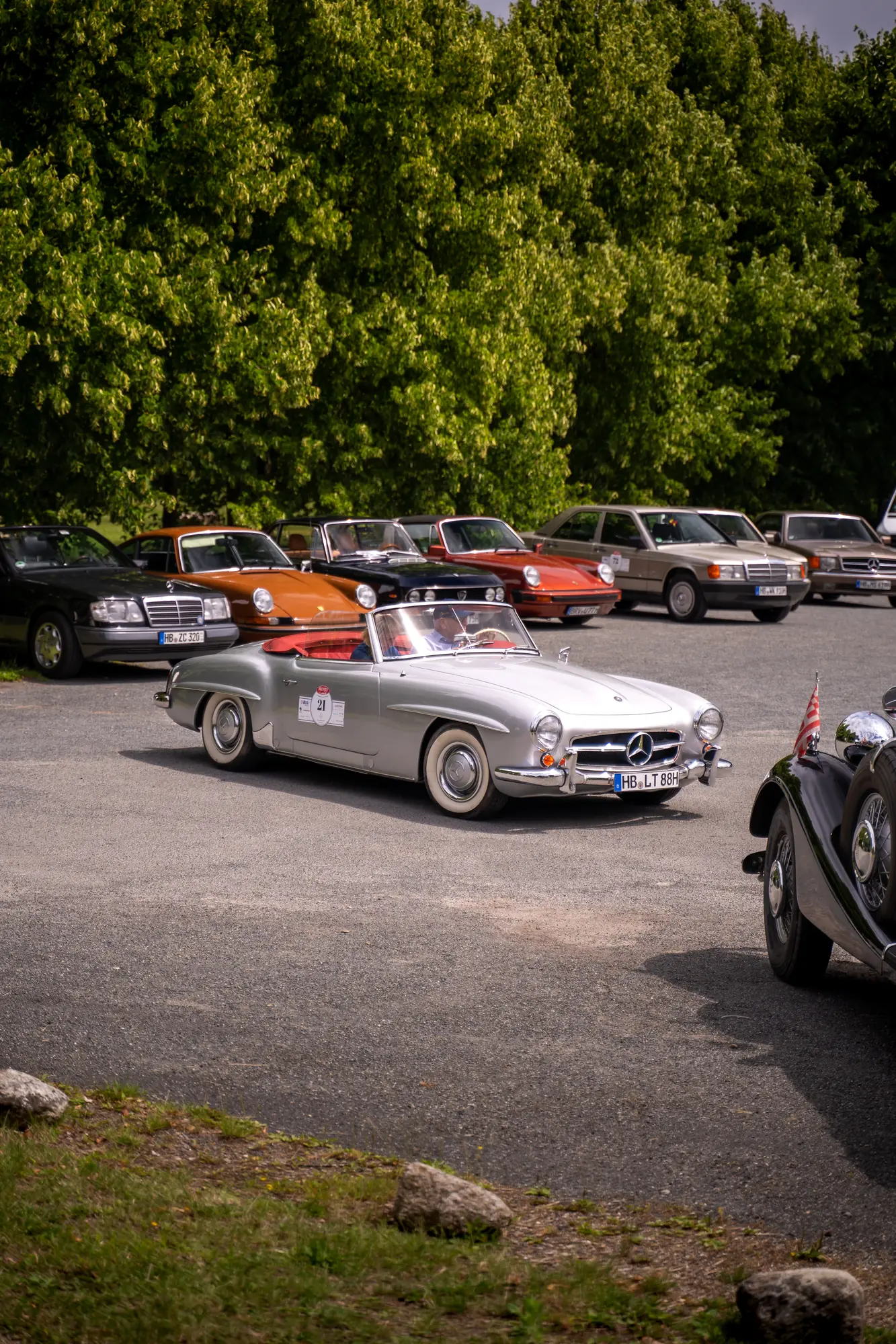 Silbernes Mercedes-Cabrio auf einem Parkplatz vor einer Baumreihe bei den BOC 2025.
