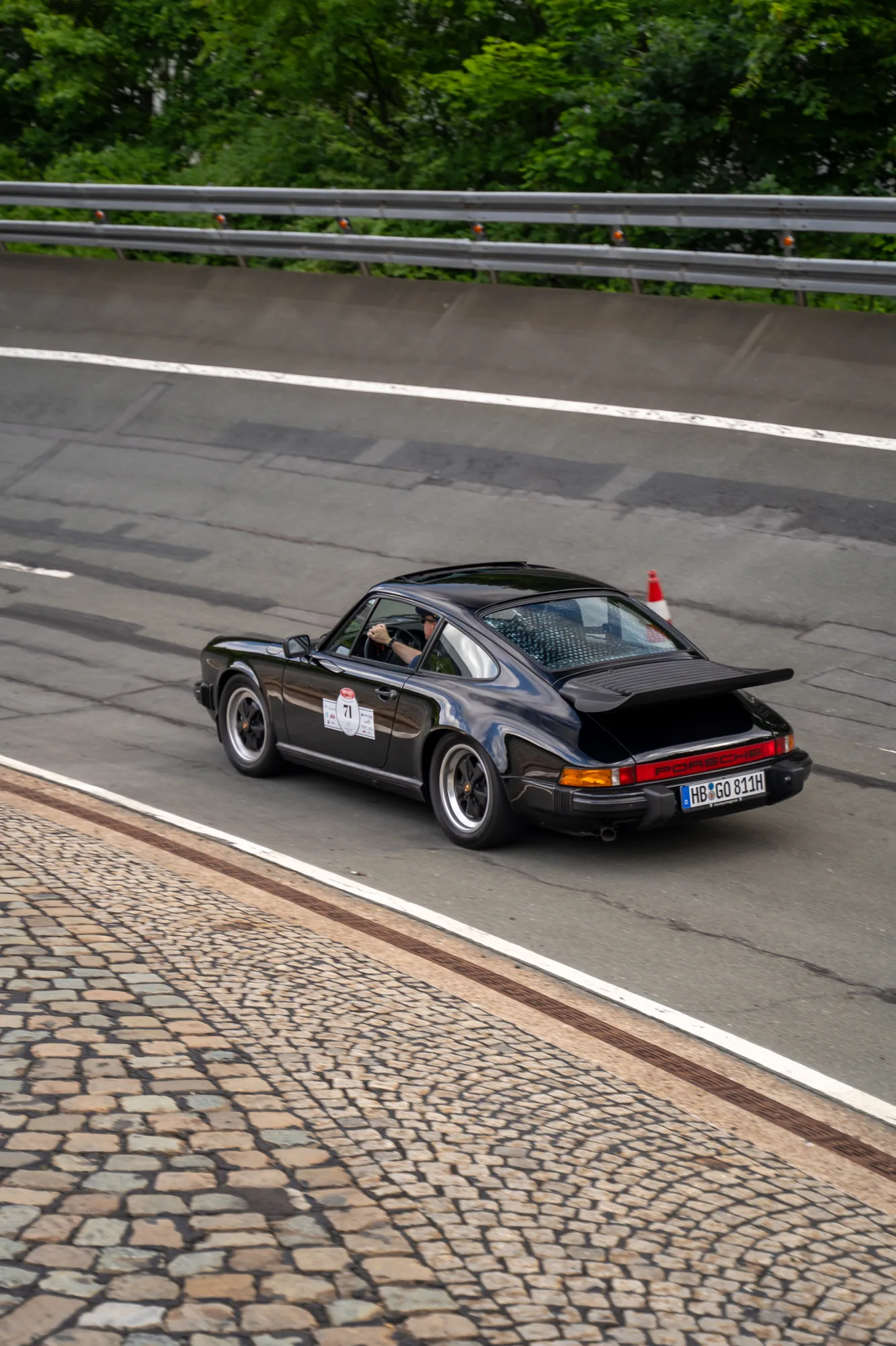 Schwarzer Porsche mit Heckflügel in einer Steilkurve bei den BOC 2025.