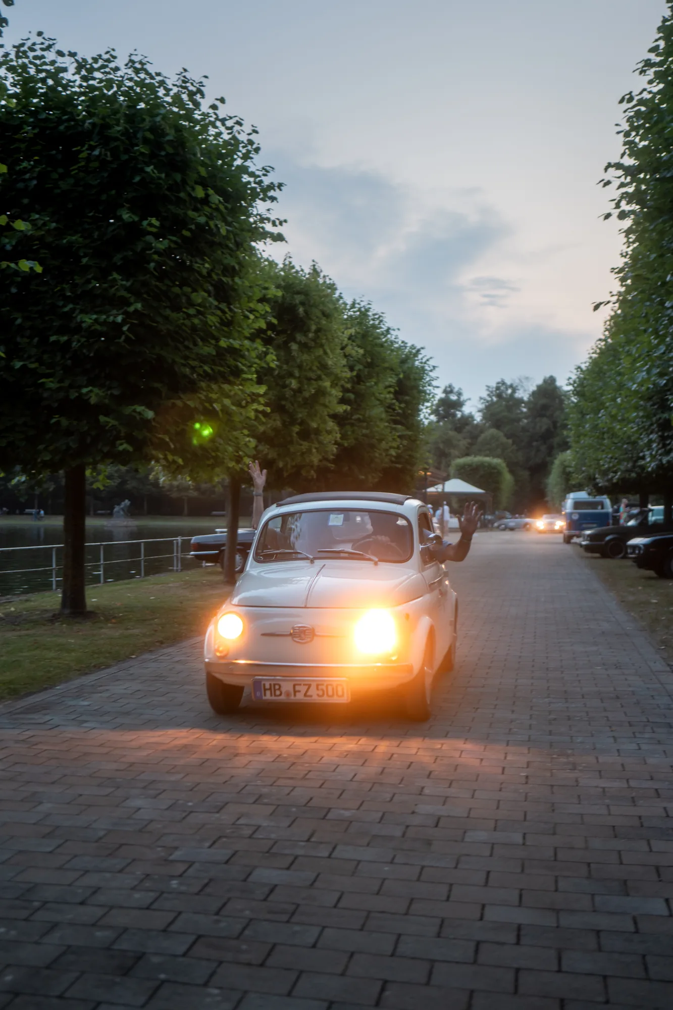 Dunkler Oldtimer mit eingeschalteten Scheinwerfern auf Kopfsteinpflaster bei den BOC 2026.