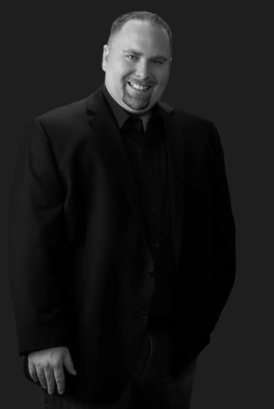 DJ Michael Chirichella, New York and New Jersey wedding DJ with Dash of Class, smiling in a black suit and dark shirt