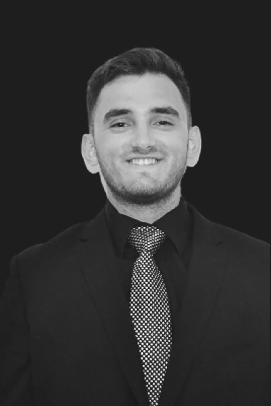 DJ Kyle, Long Island wedding DJ with Dash of Class Platinum Entertainment, smiling in a black suit and patterned tie