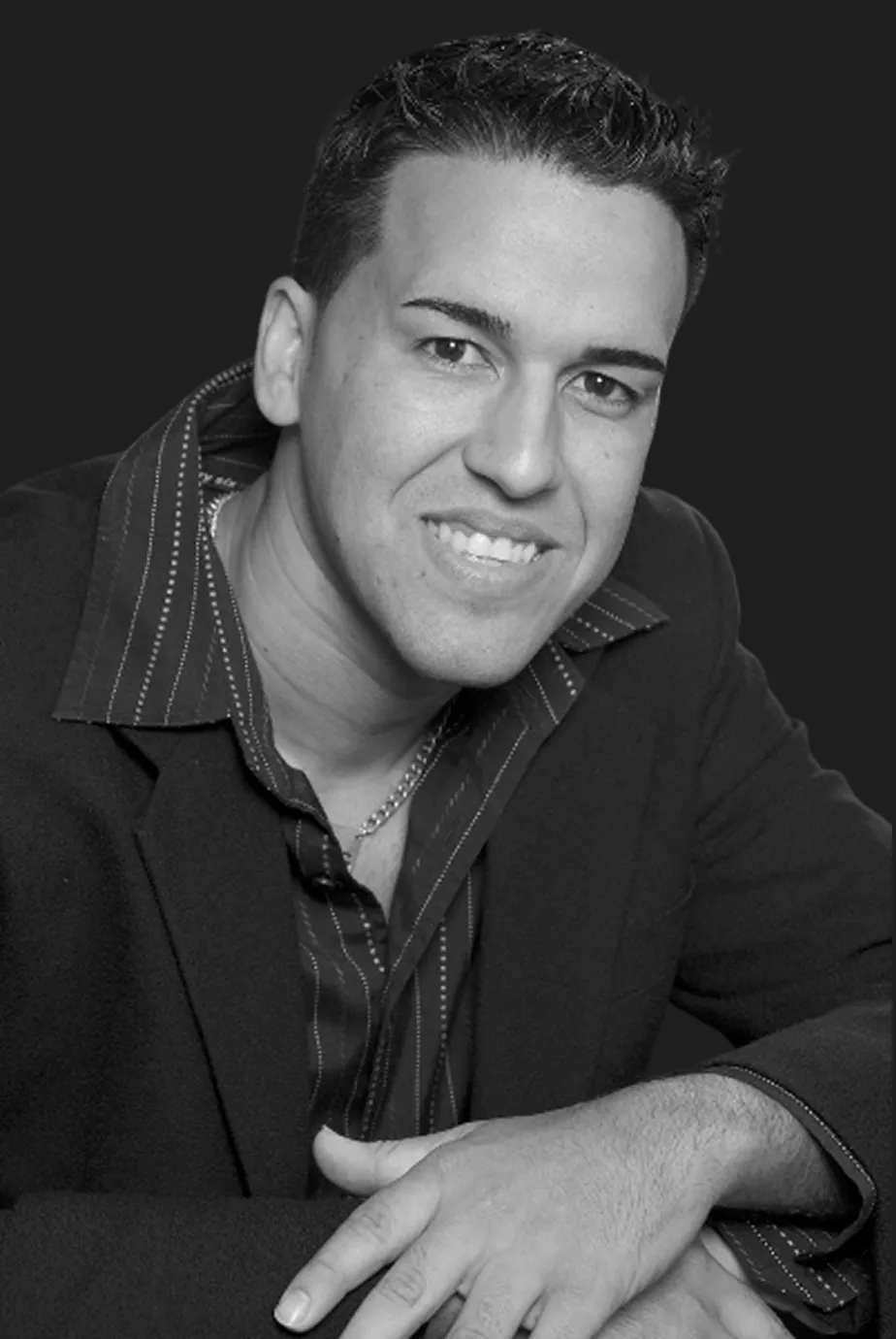 DJ Carlos Carrion, Florida wedding DJ with Dash of Class Platinum Entertainment, smiling in a blazer and striped shirt