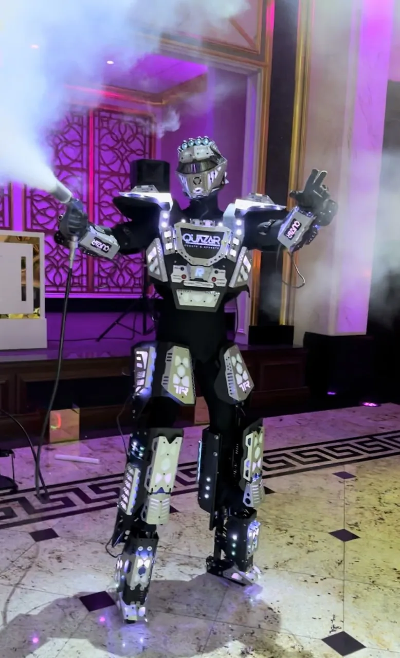 LED robot performer in a light-up costume spraying CO2 on a reception dance floor