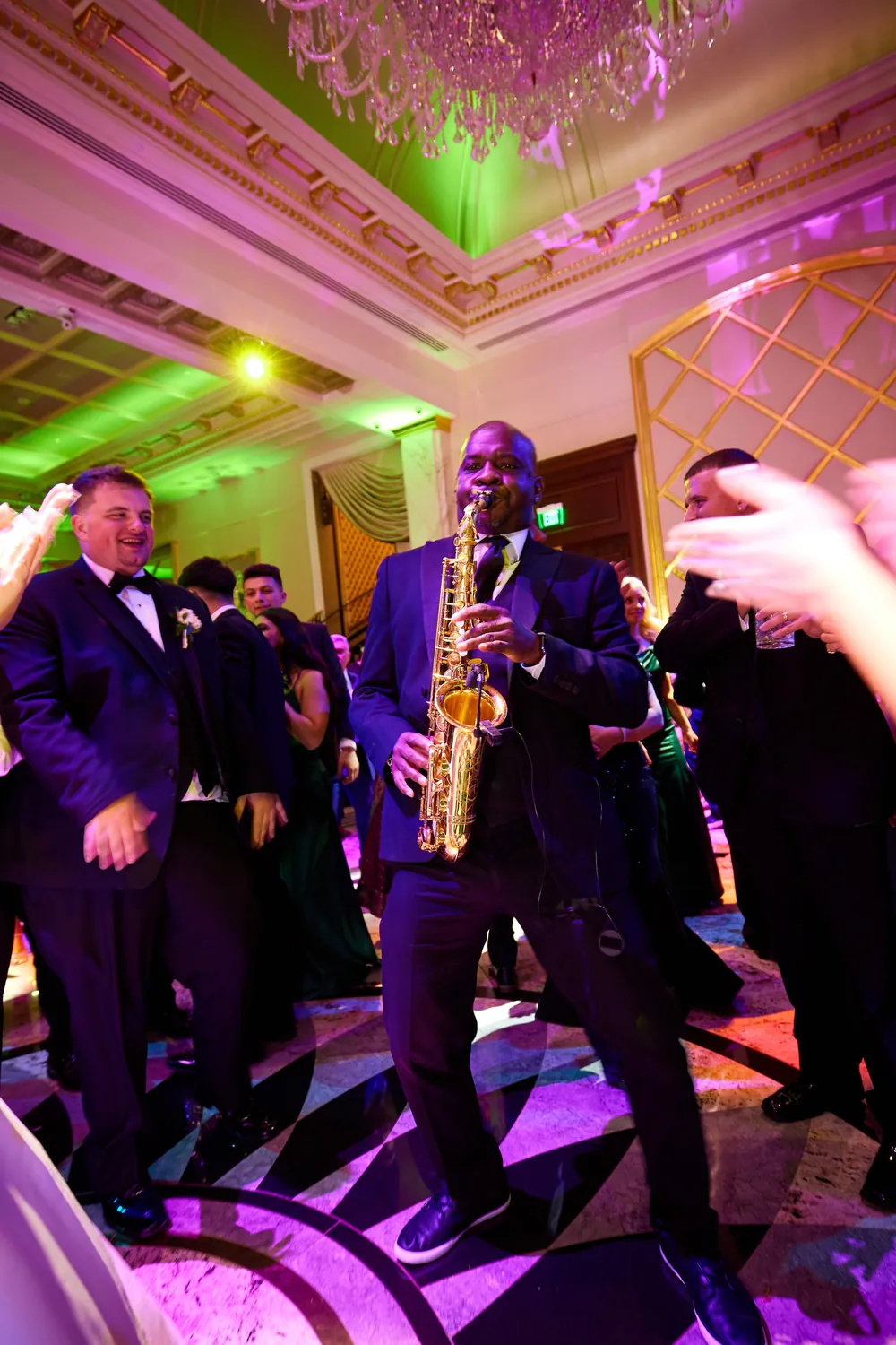 Saxophonist playing among dancing guests on a ballroom dance floor, a live music add-on