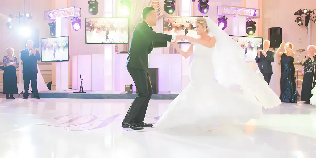 Bride and groom's first dance on a white LED dance floor with video screens, moving lights and a DJ setup behind them