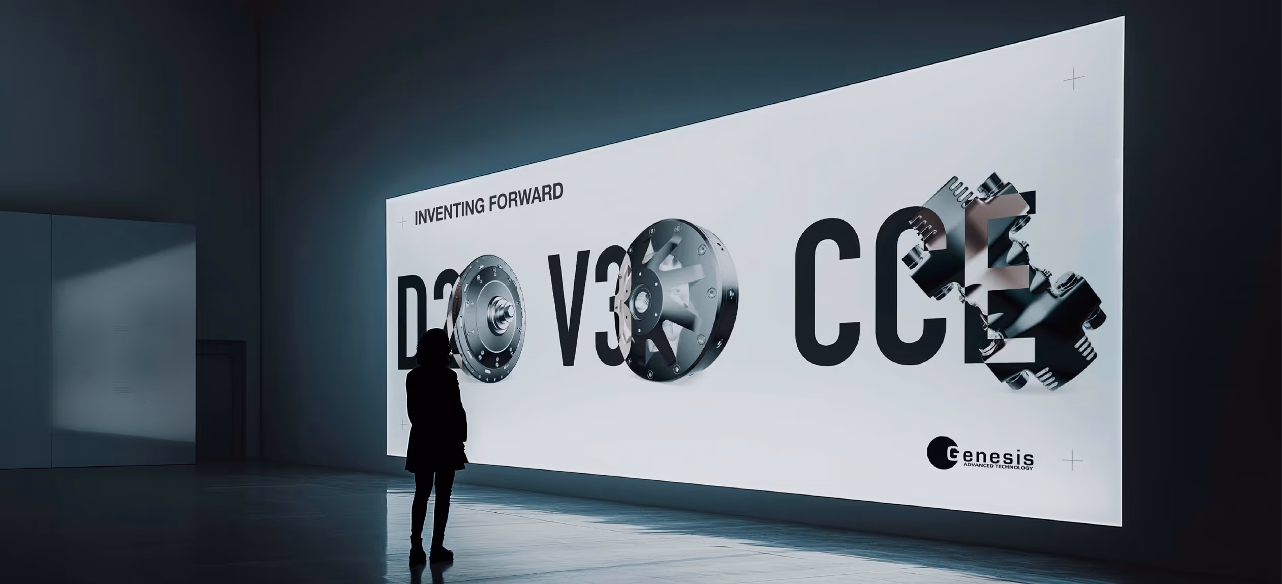 A woman standing in front of a large LED screen projecting Genesis Advanced Technology branding elements.