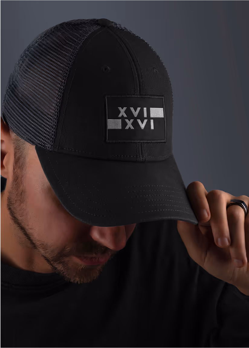 An image of a man modelling the 1616 hat merchandise. 