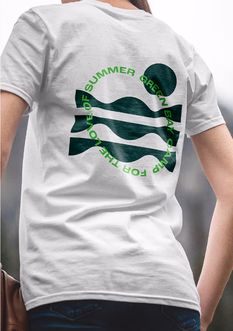 A young woman facing backwards wearing green by bible camp merchandise.