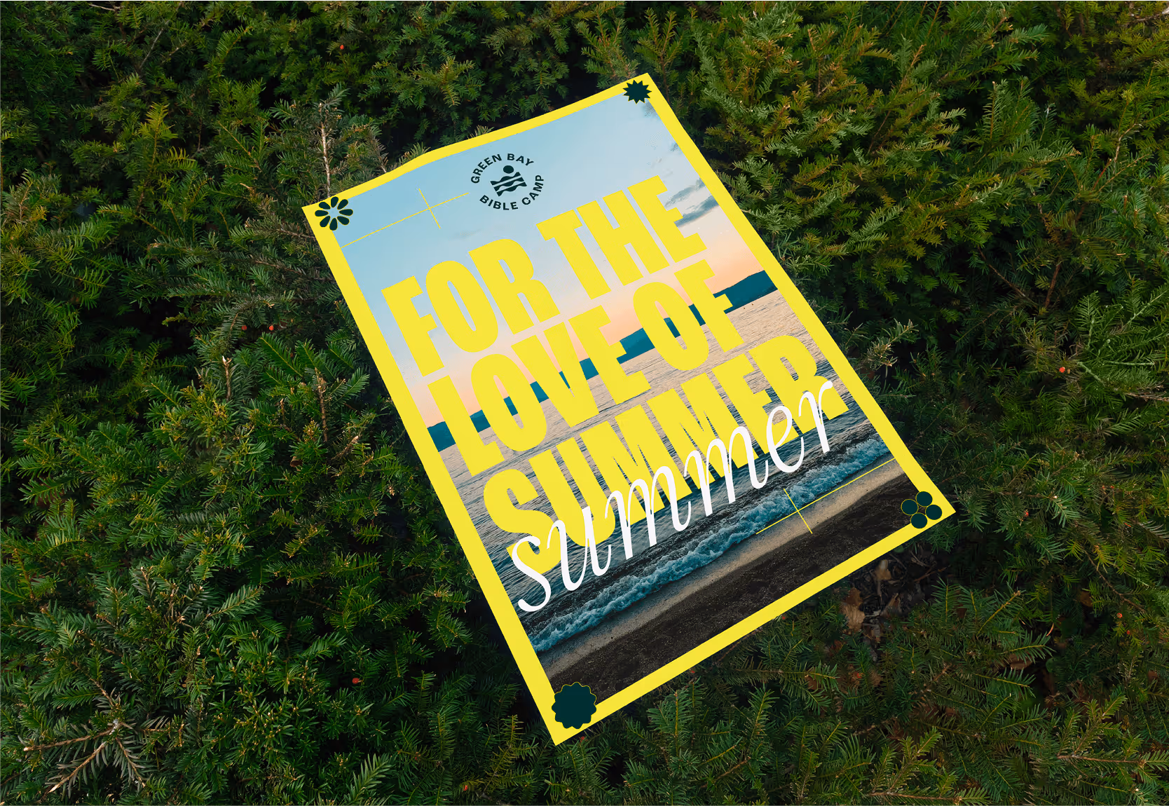 A flat lay image of a green bay bible camp poster laying on grass.