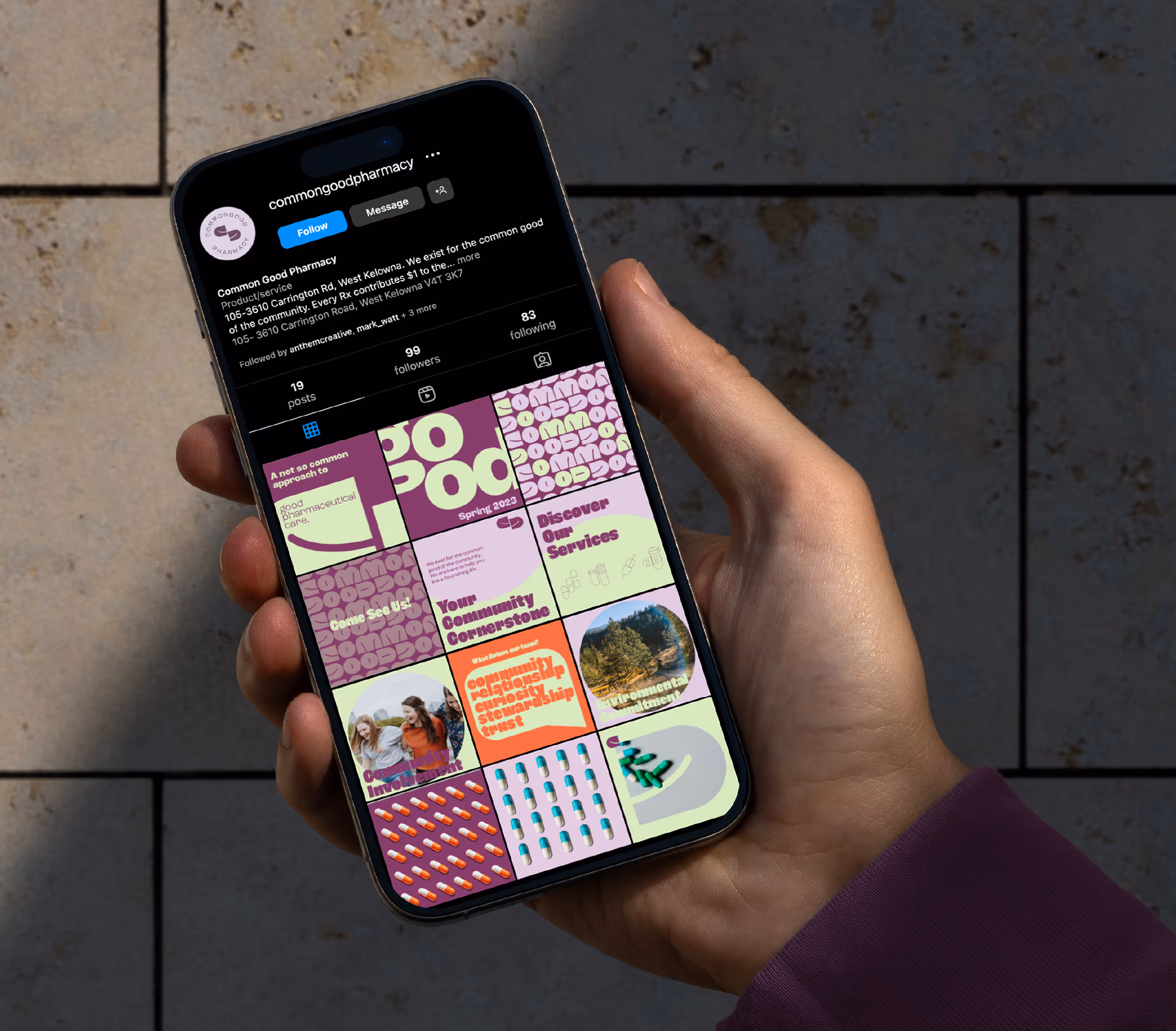 A POV view of a person holding an iPhone showcasing the Common Good instagram profile grid.