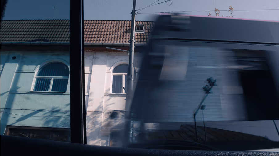 A blurred mage of a building in Romania, as a car drives by.
