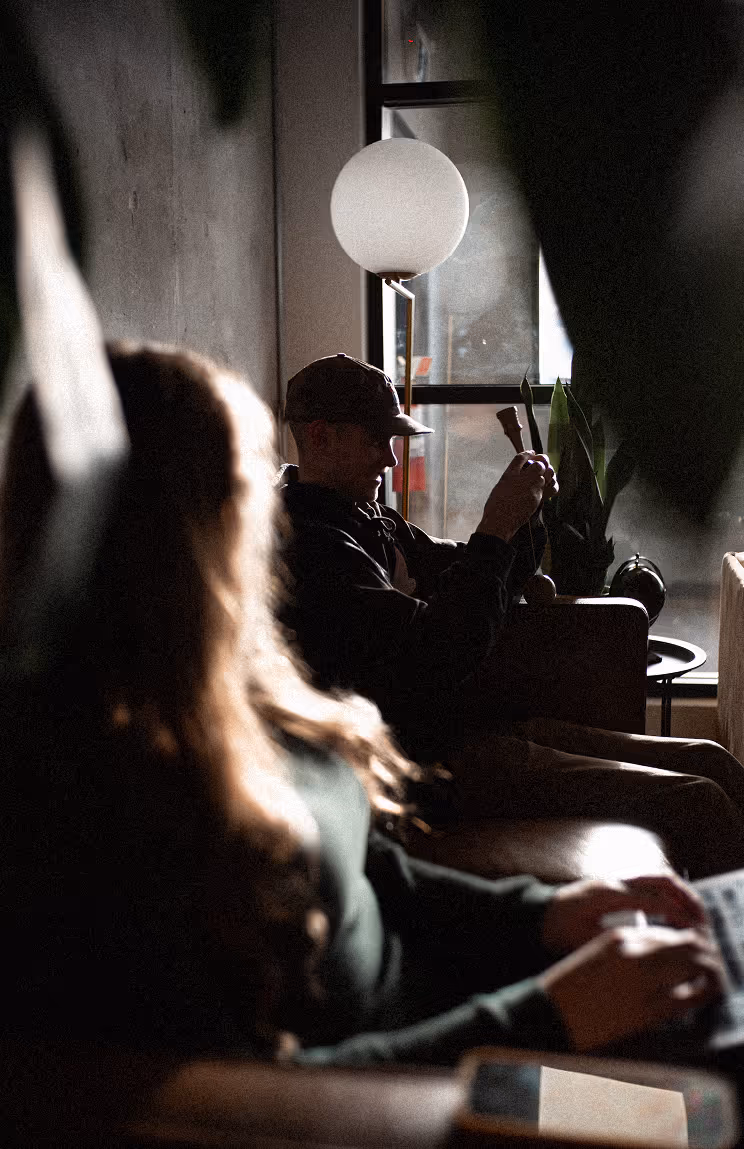 A woman and man working on laptops while sitting on a couch