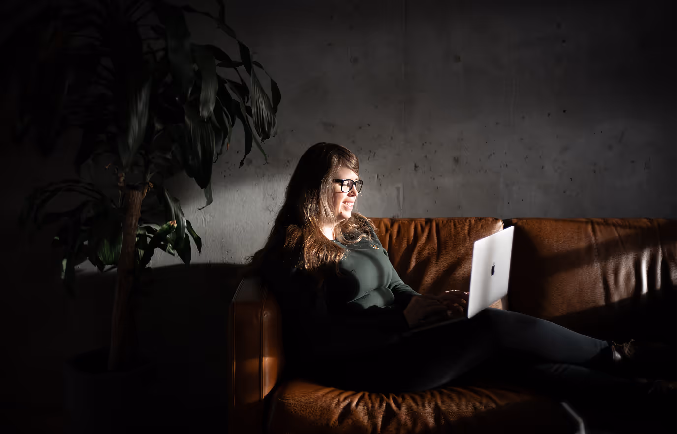 a woman sitting on a couch with a laptop