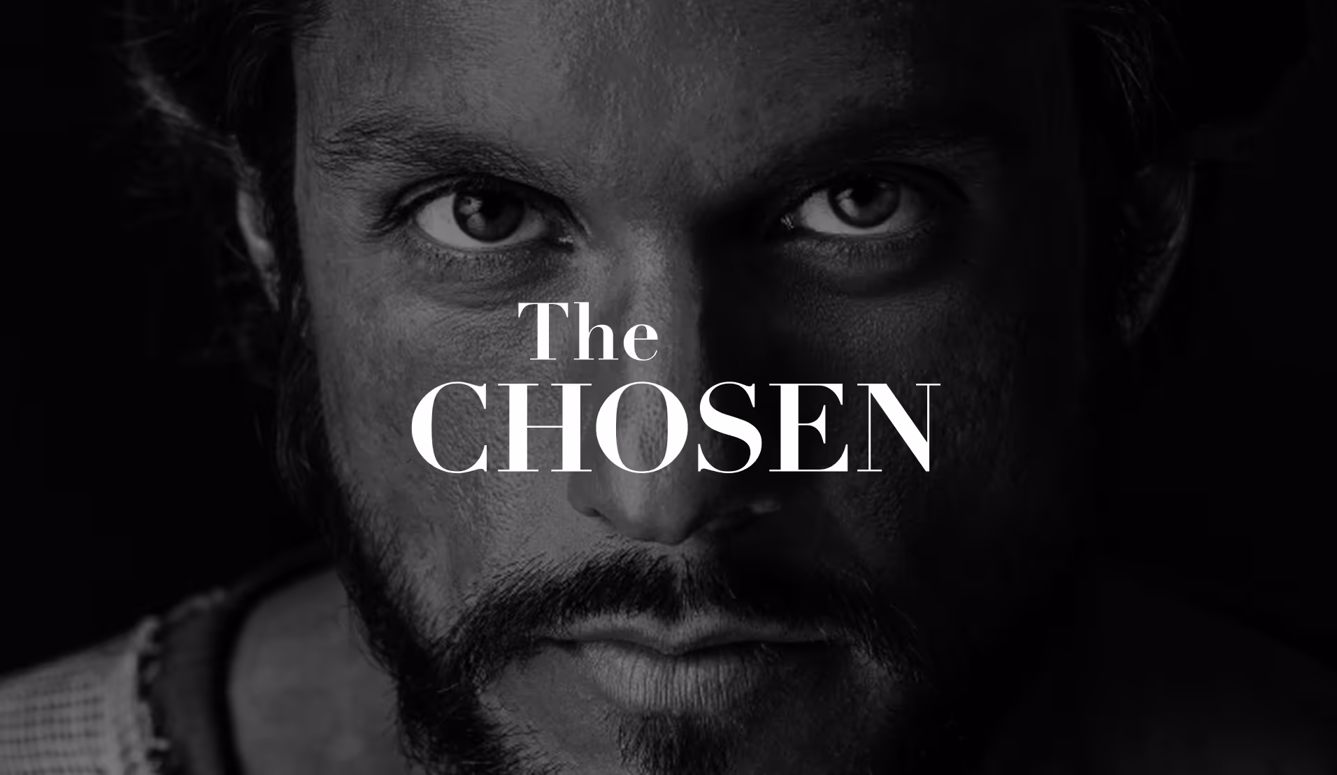 A closeup of a mans face with The Chosen logo overtop