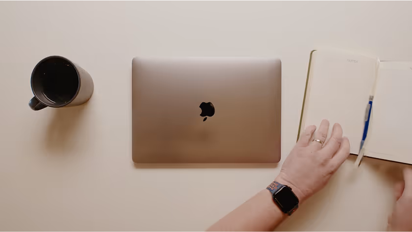 An image of a still showcasing a man opening his notebook.