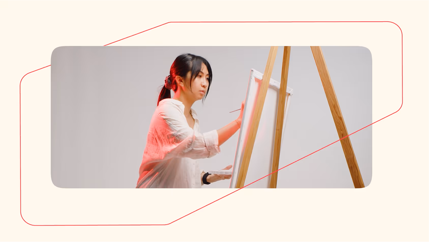 An video still of a lady painting on a easel.