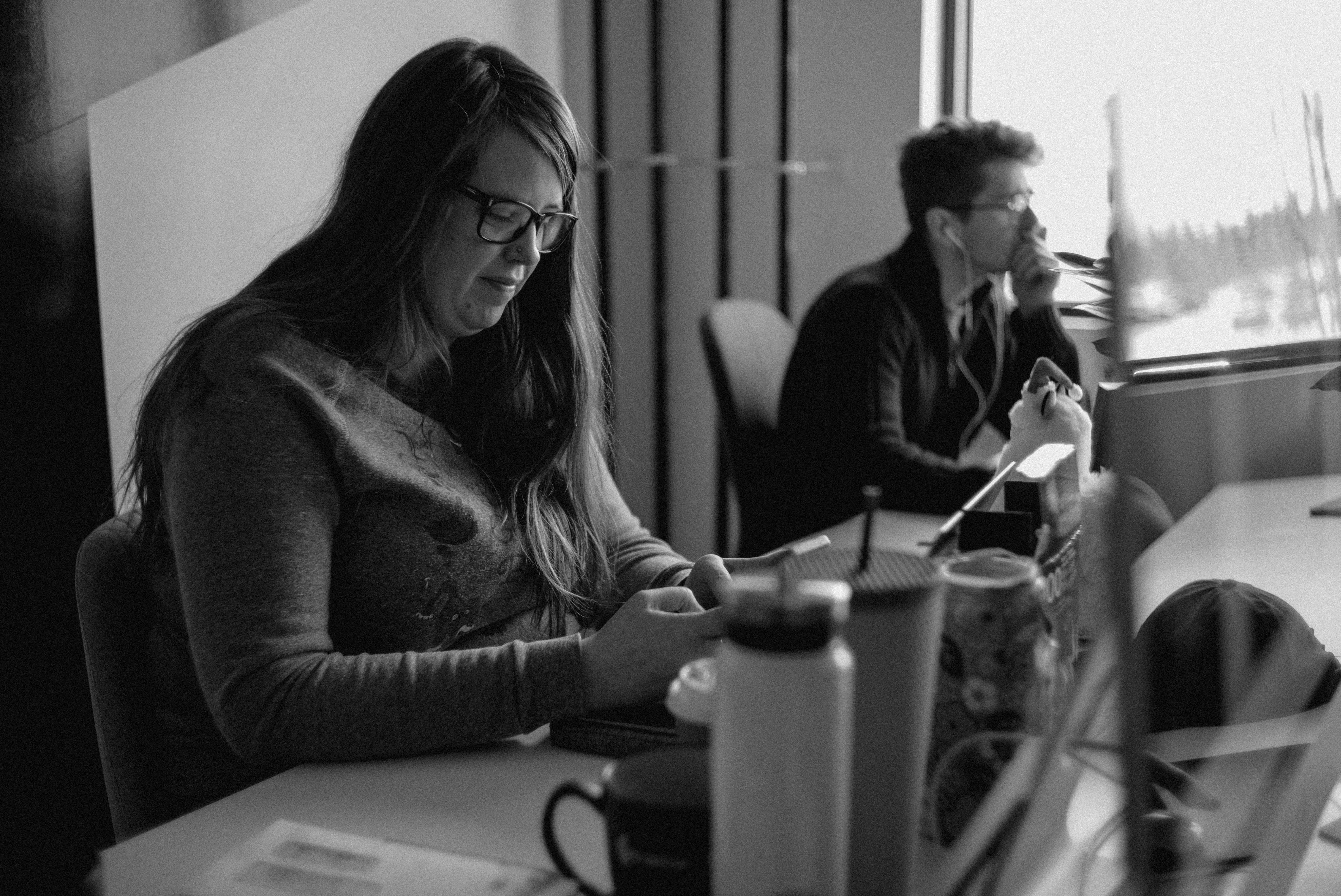 A back and white photo of a man and woman sitting at a desk