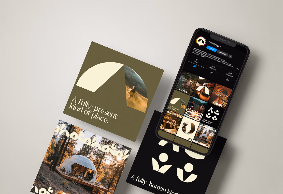 Smartphone displaying a social media profile with outdoor lifestyle images, placed on top of printed cards showing a dome cabin, abstract designs, and phrases about presence and place.