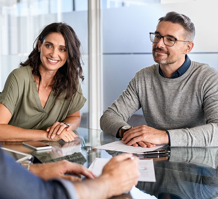 woman and man sitting at a table about to sign a document
