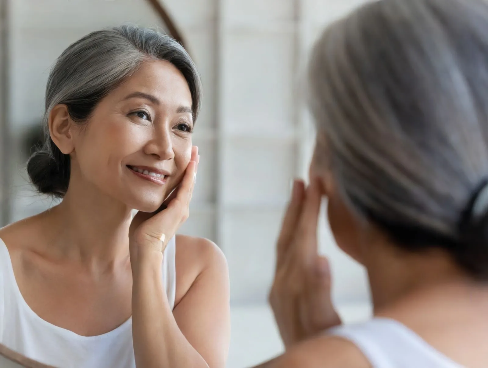 Woman smiling at herself in a mirror