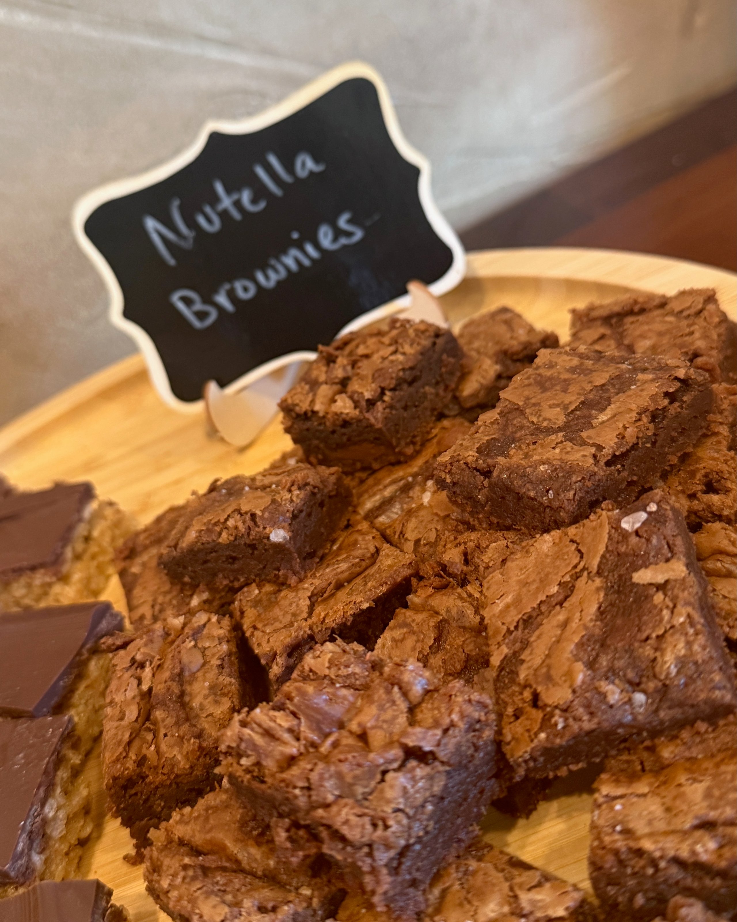 Fudgy Nutella brownies with crackly top on wooden board
