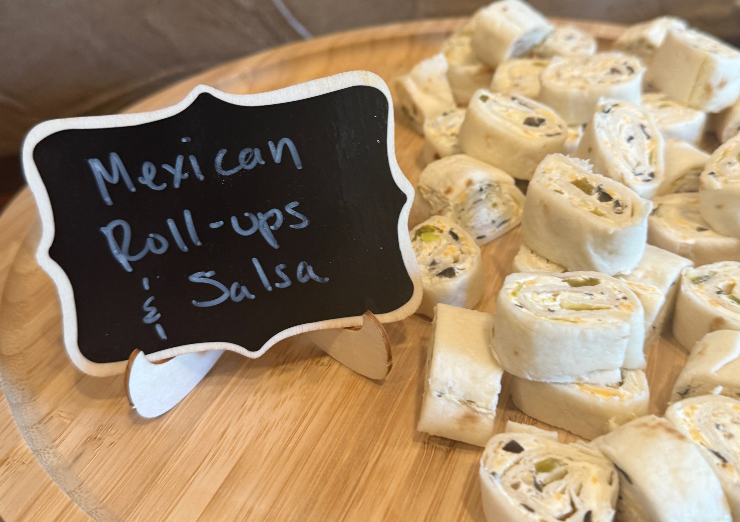 Mexican roll-ups with salsa on a wooden board